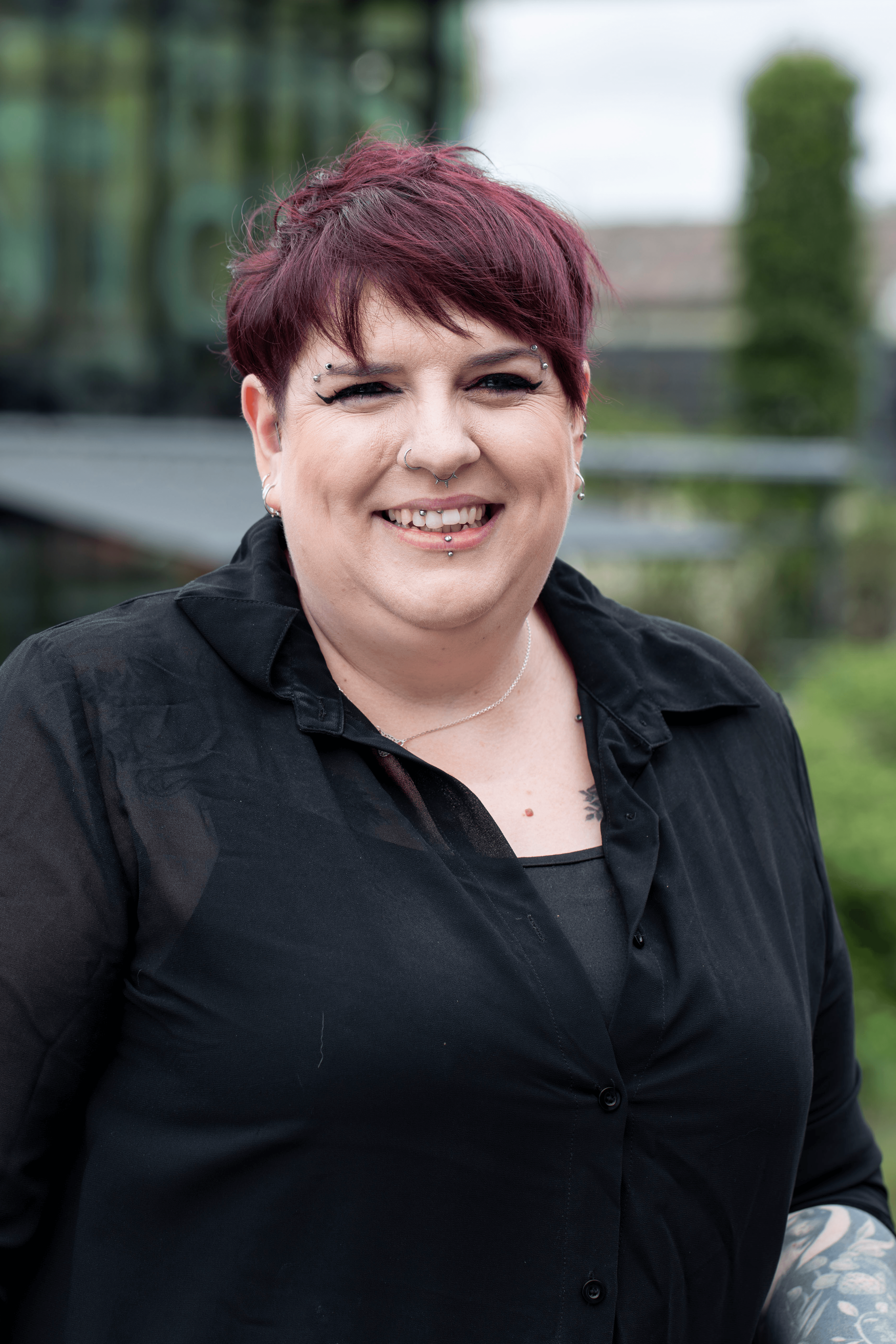 Rachel Lee, Senior AV Specialist at Lincoln University, smiling and standing outdoors with greenery and buildings in the background.